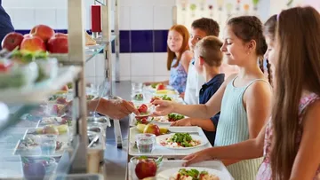 Kinder holen sich ihr Mittagessen in der Schulkantine.